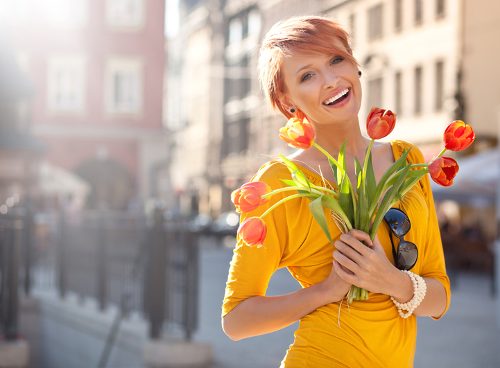 Smiling woman with bouquet of orange tulips